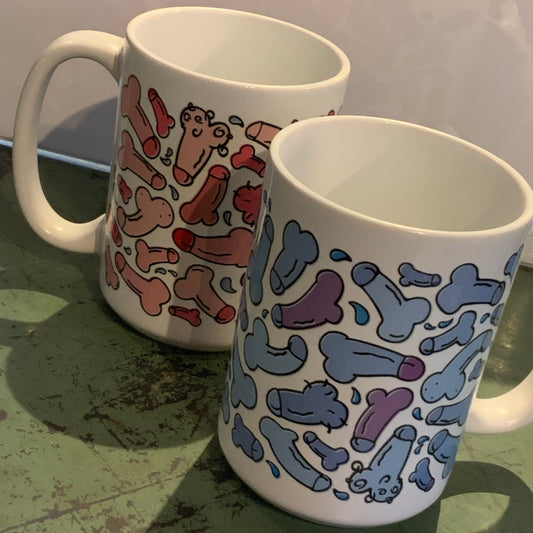 Two mugs with colorful abstract designs on a textured surface.